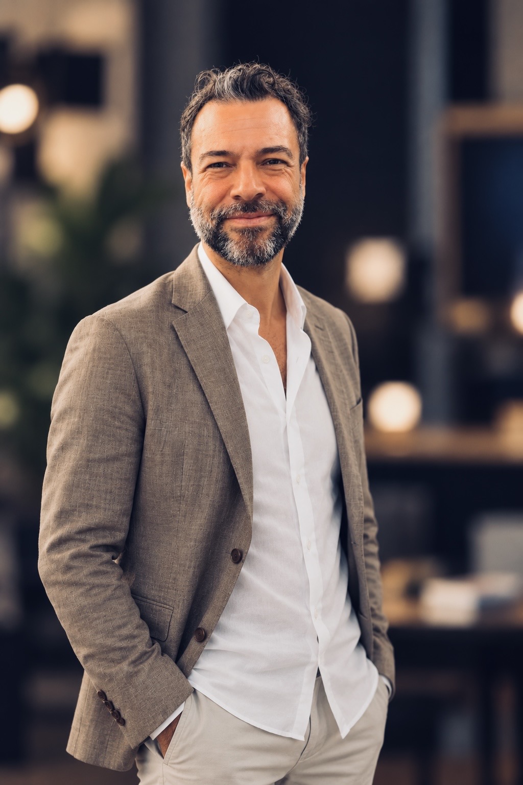 Mert Ruscuklu on set, smiling in a brown jacket